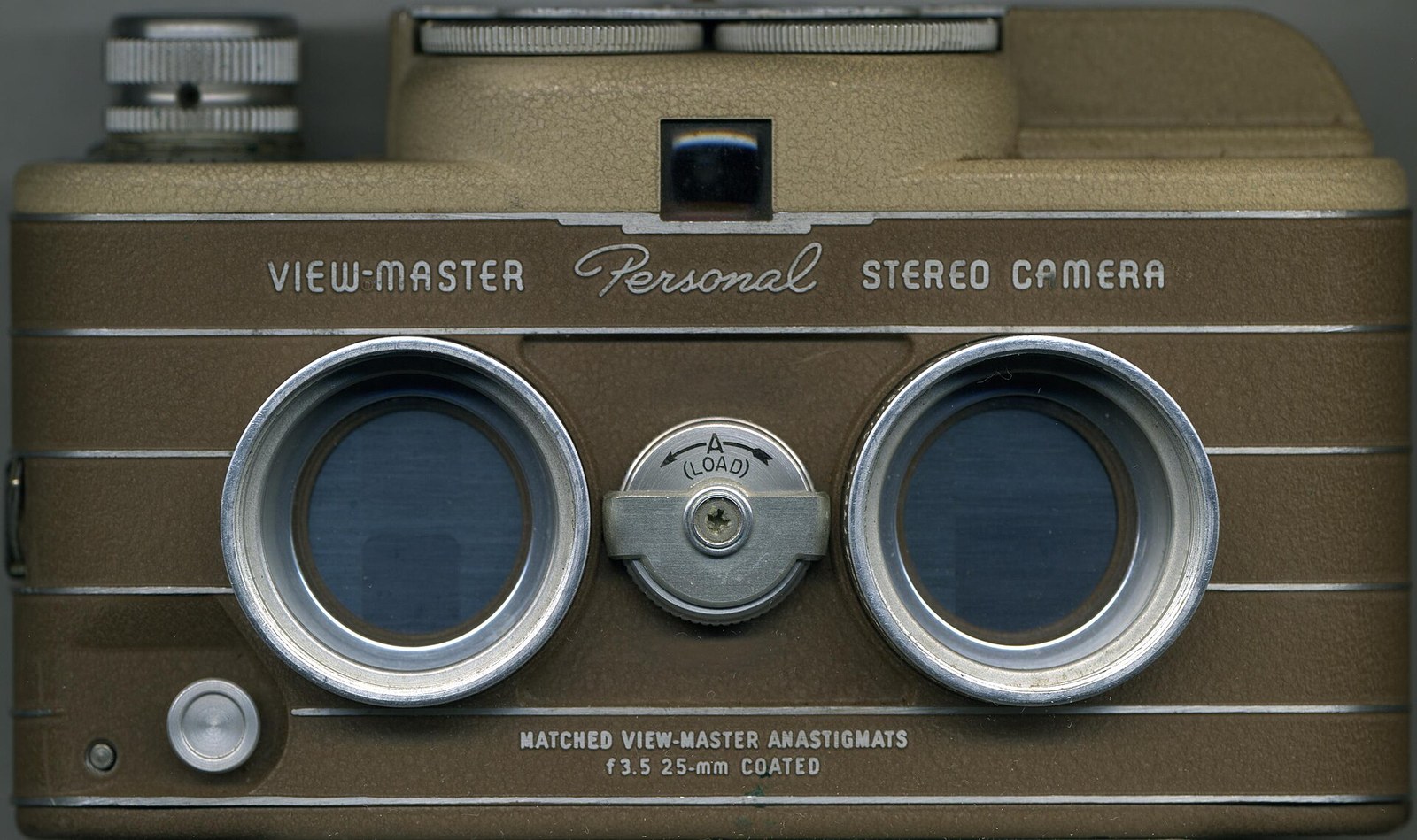The front of a View-Master Personal Stereo Camera, a brown metal camera with two lenses side by side.