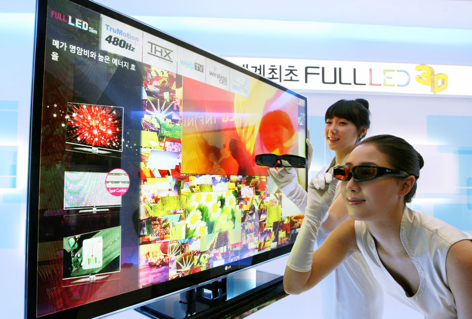 An LG 3D television at its 2010 launch, with one presenter wearing its 3D glasses and another holding a pair.