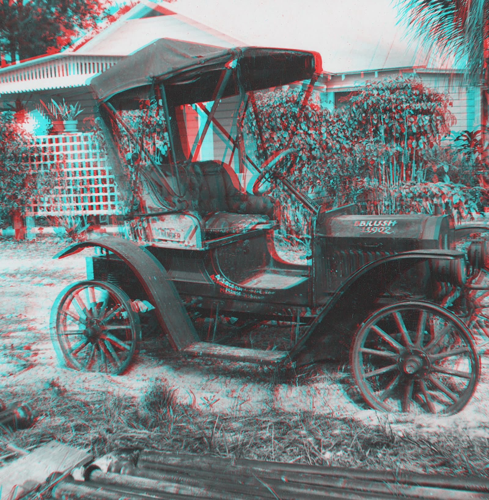 Red-cyan anaglyph 3D picture of an early open automobile parked in front of a house
