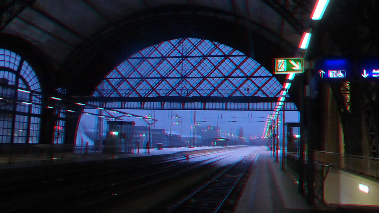 Ein rot-cyanfarbenes Anaglyphenbild der Bahnsteighalle des Dresdner Hauptbahnhofs mit einem Zug.