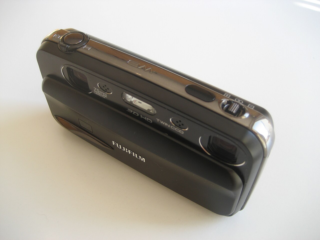Eine kompakte Fujifilm-Kamera mit zwei Objektiven an den Enden der Frontseite, zwischen ihnen der Aufdruck „75mm“.