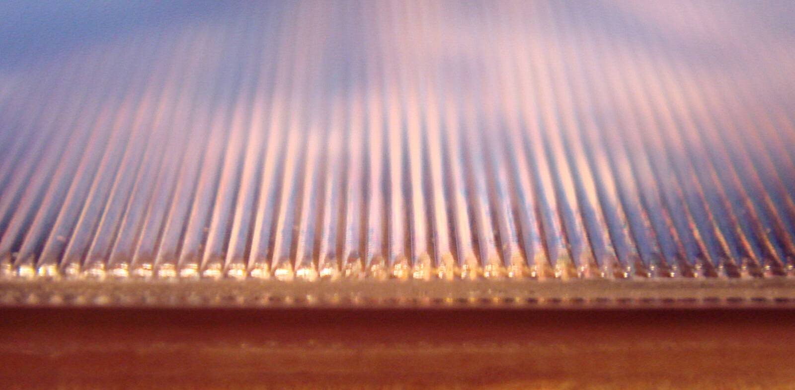 Close view across the surface of a lenticular print, showing its rows of parallel ridges.