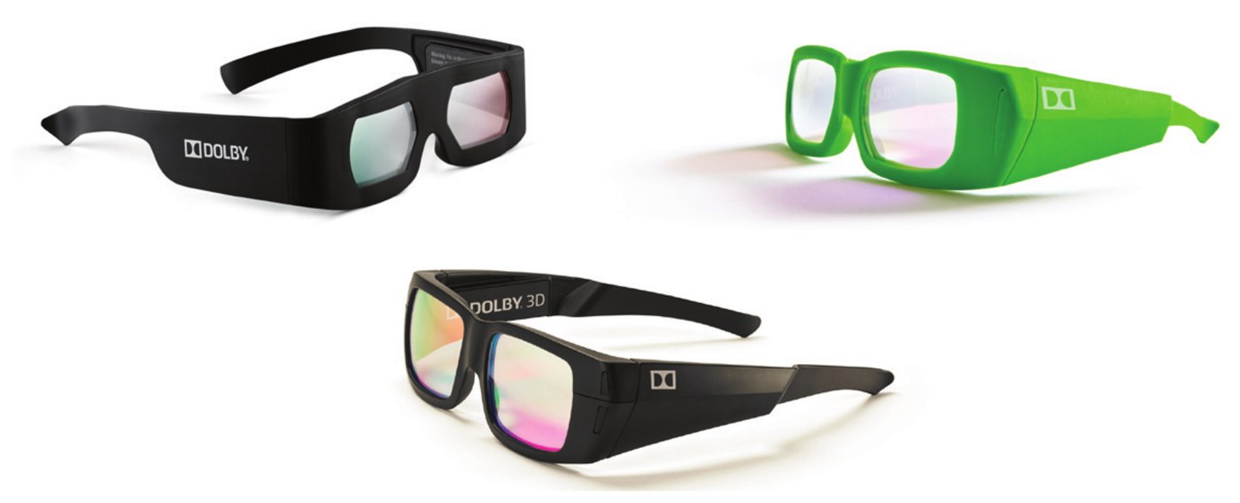 Three pairs of Dolby 3D glasses, two black and one green, with thick frames and lenses that reflect pink and green.