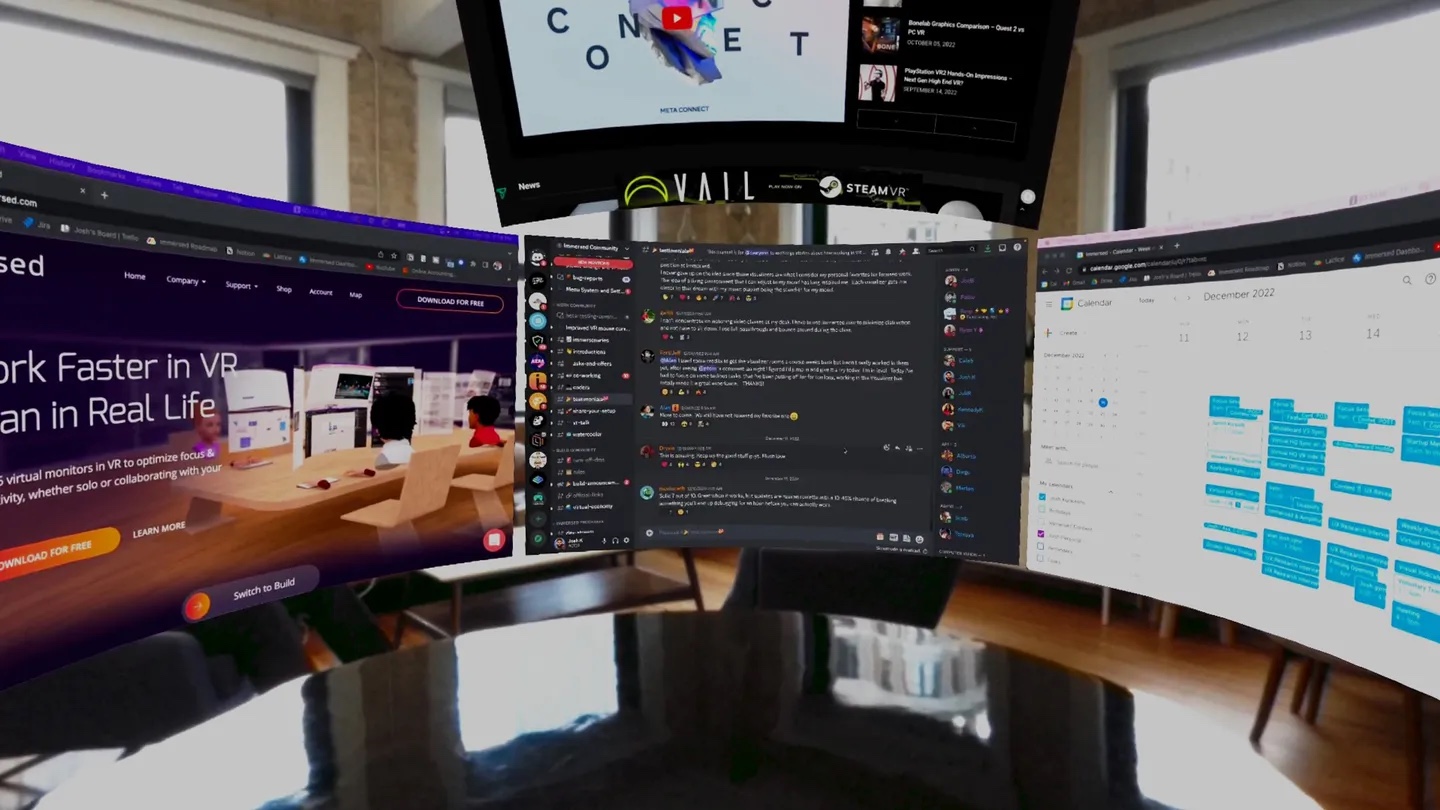 Three large virtual monitors in an arc showing a web page, a chat app and a calendar, with a fourth above.