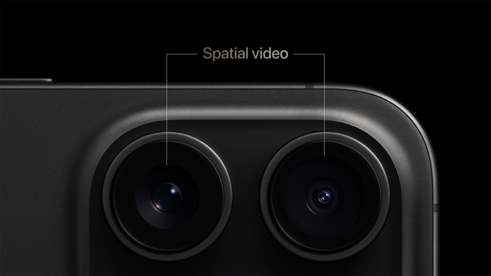 iPhone 15 Pro 背面相機的特寫,兩條線從英文字 Spatial video 往下,各指著一顆鏡頭。